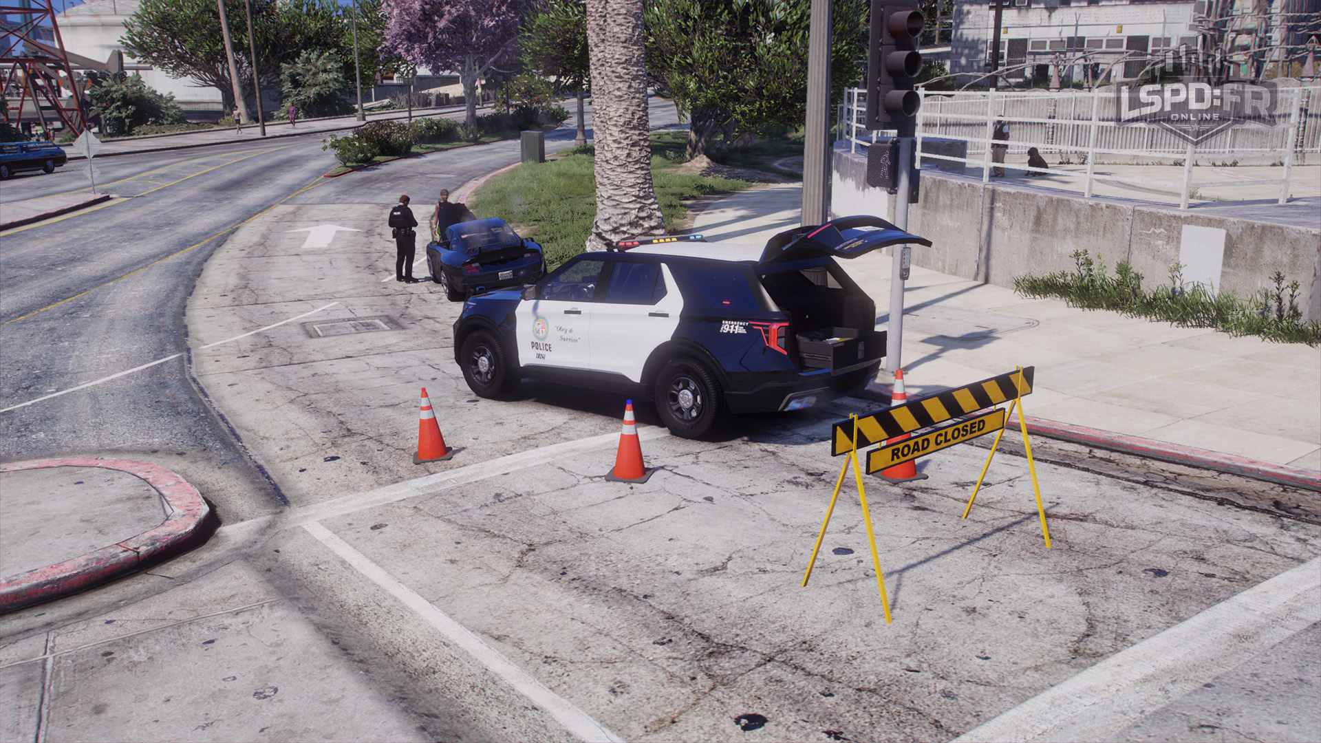 New illuminated police cones and road closed barrier deployed beside a patrol vehicle